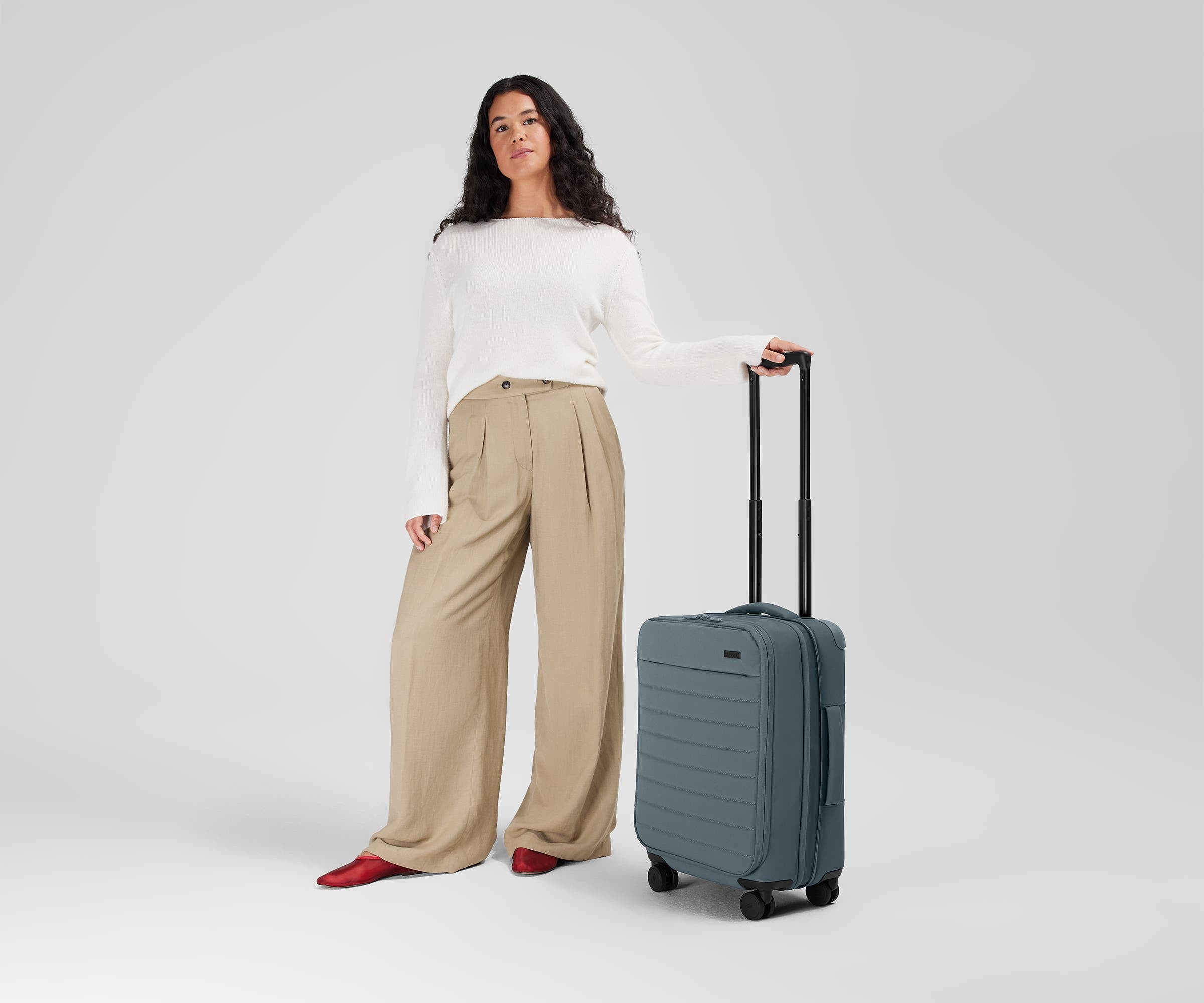 5'7" person standing next to the Softside Carry-on for scale