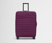 Front product view of The Softside Large suitcase in Plum Purple with raised handle