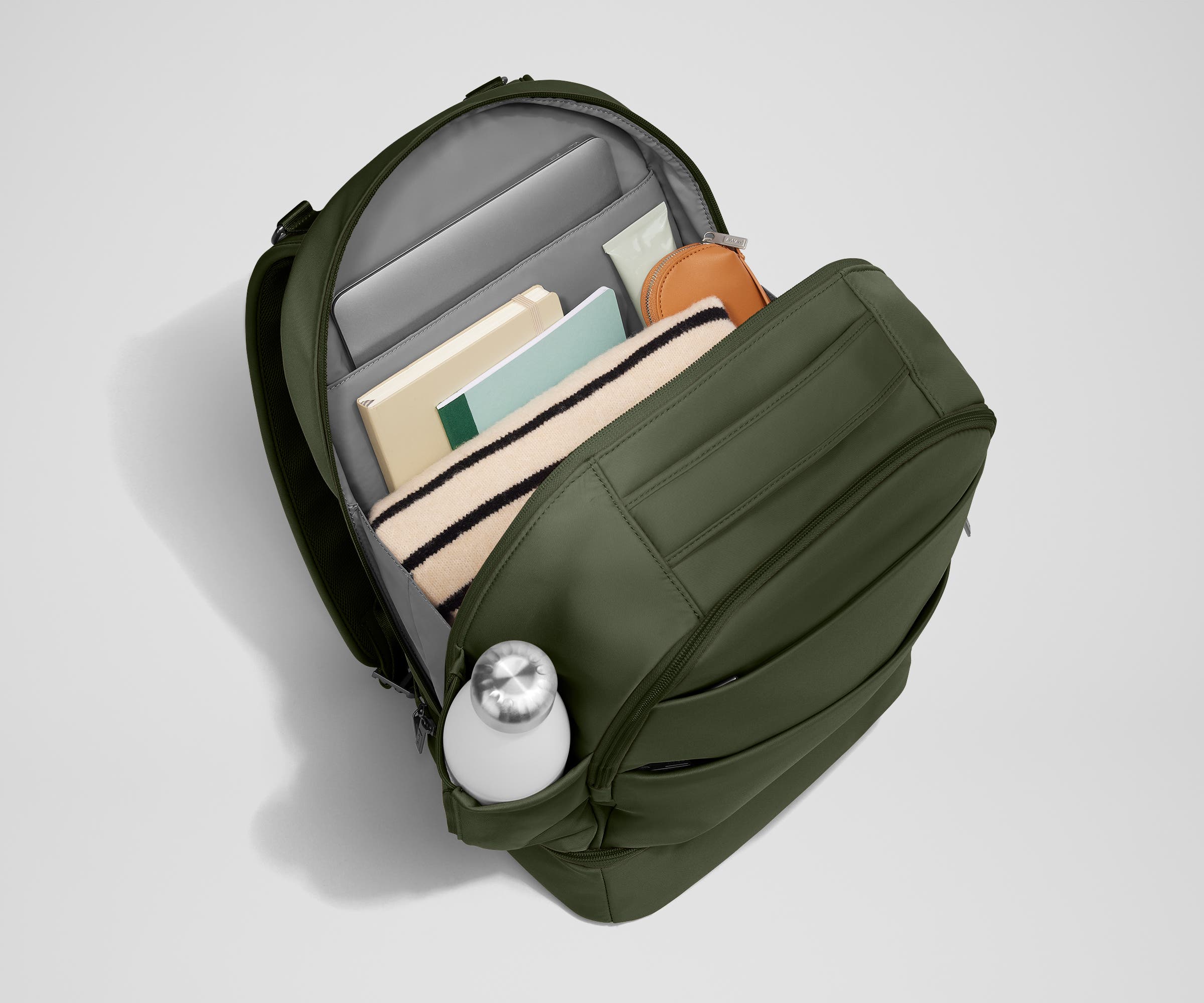 Back main compartment packed with adult travel essentials, including a laptop, notebook, and extra clothes
