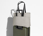 Everywhere Tote secured to an Away suitcase by its trolley sleeve