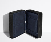 The Medium suitcase in Jet Black shown open in an upright position to show interior organization and compression system