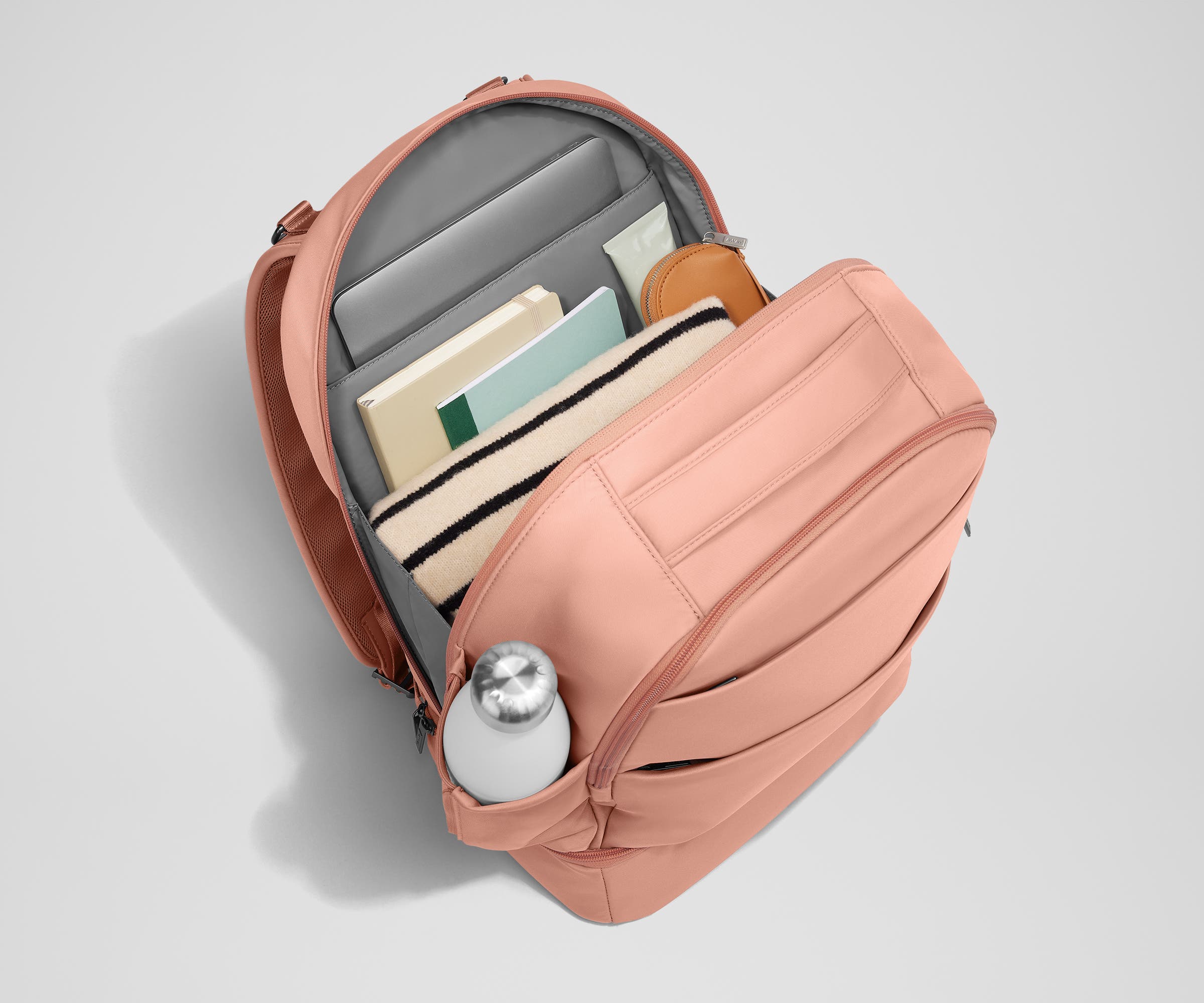 Back main compartment packed with adult travel essentials, including a laptop, notebook, and extra clothes