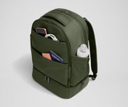 Exterior front pockets packed with travel essentials like a passport and phone, and the exterior bottle pocket packed with a milk bottle