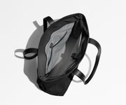 Unzipped and unpacked Everywhere Tote bag, showing the interior zip pockets, slip pockets, and laptop pocket