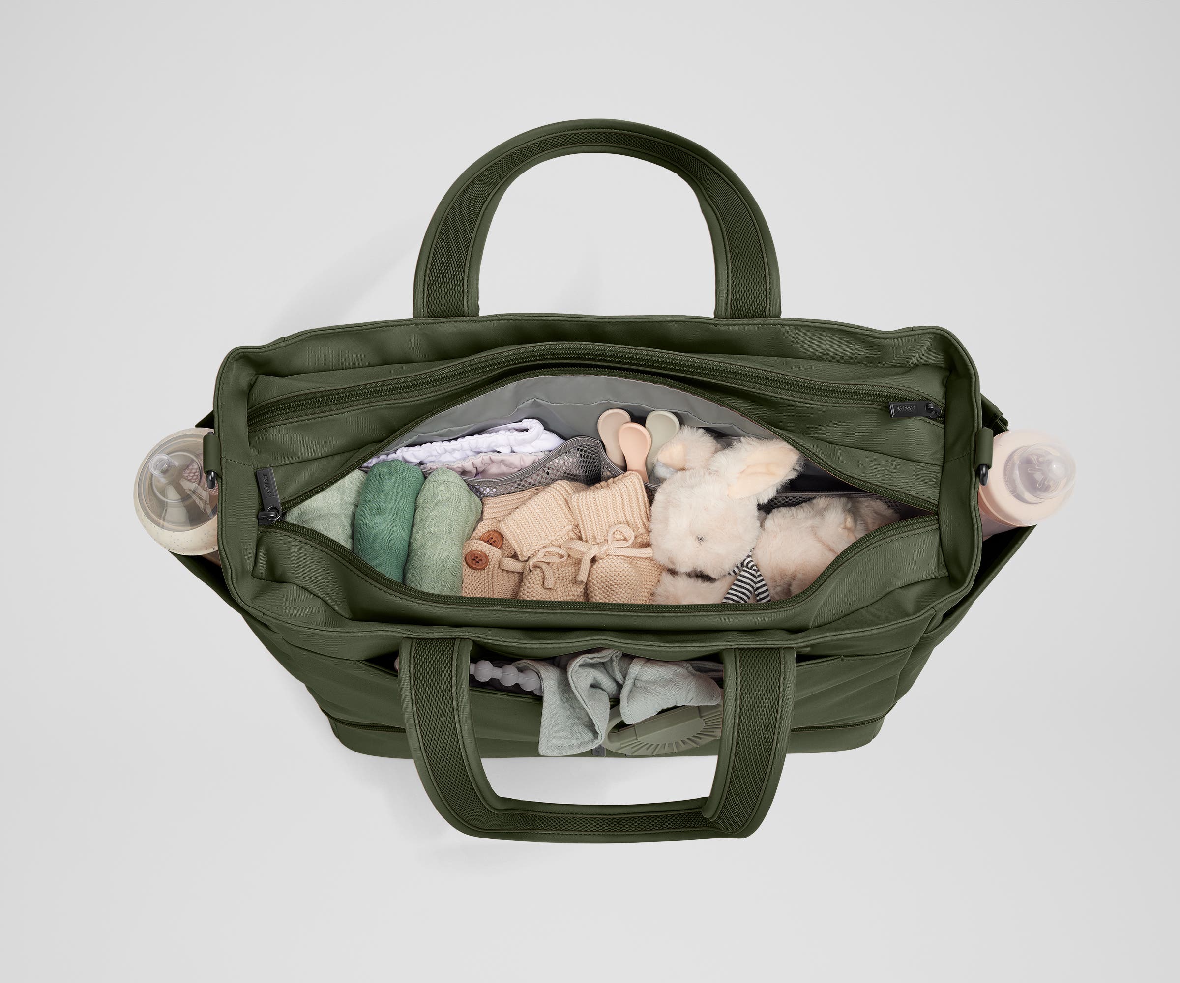 Front main compartment packed with child essentials, including a stuffed animal, wipes, and change of clothes
