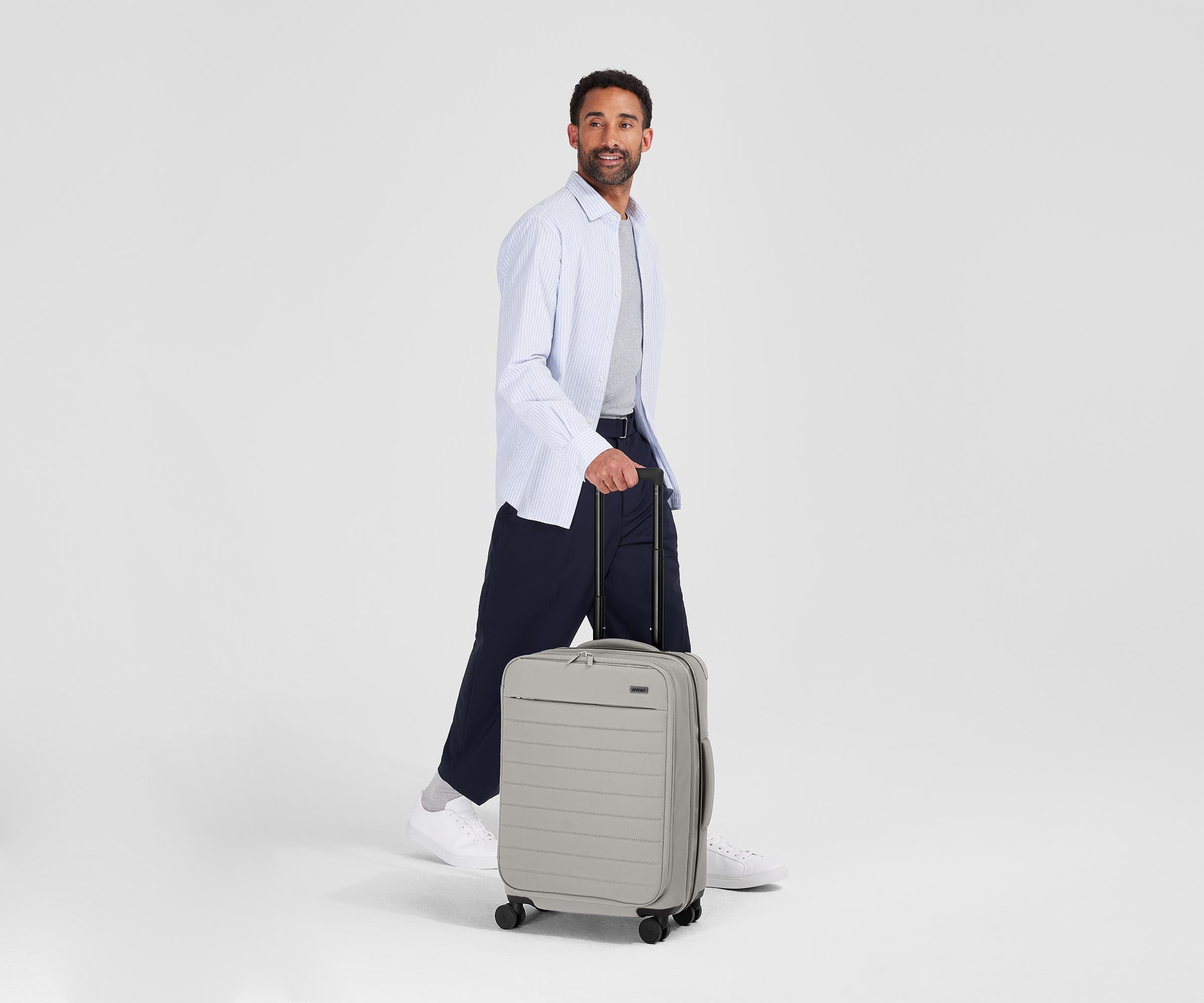 Person standing next to the Softside Bigger Carry-on for scale