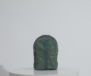 Main compartment packed with an organizational pouch, notebook, and headphones. Water bottle in the exterior water bottle pocket